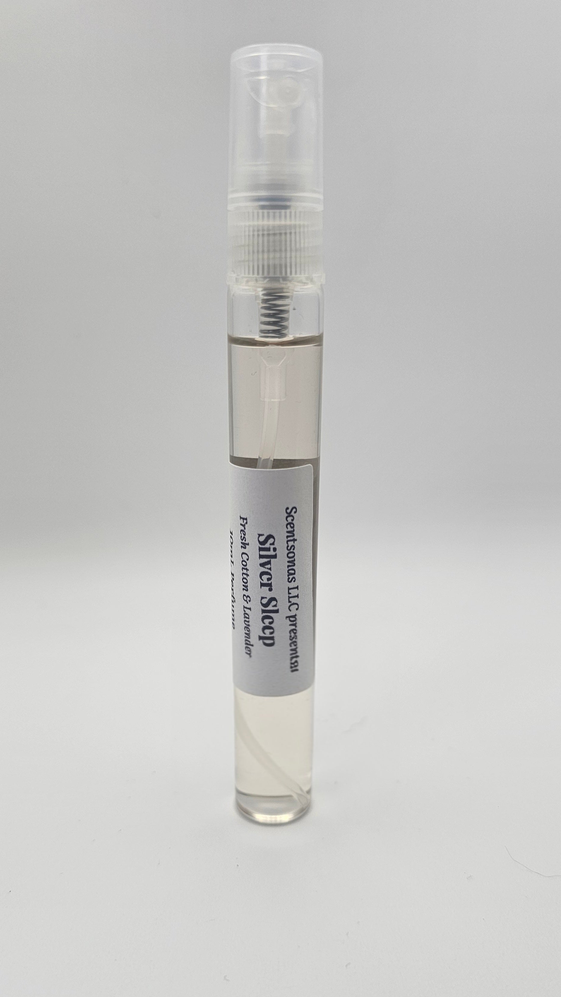 Small spray bottle with a gray label on a light gray background